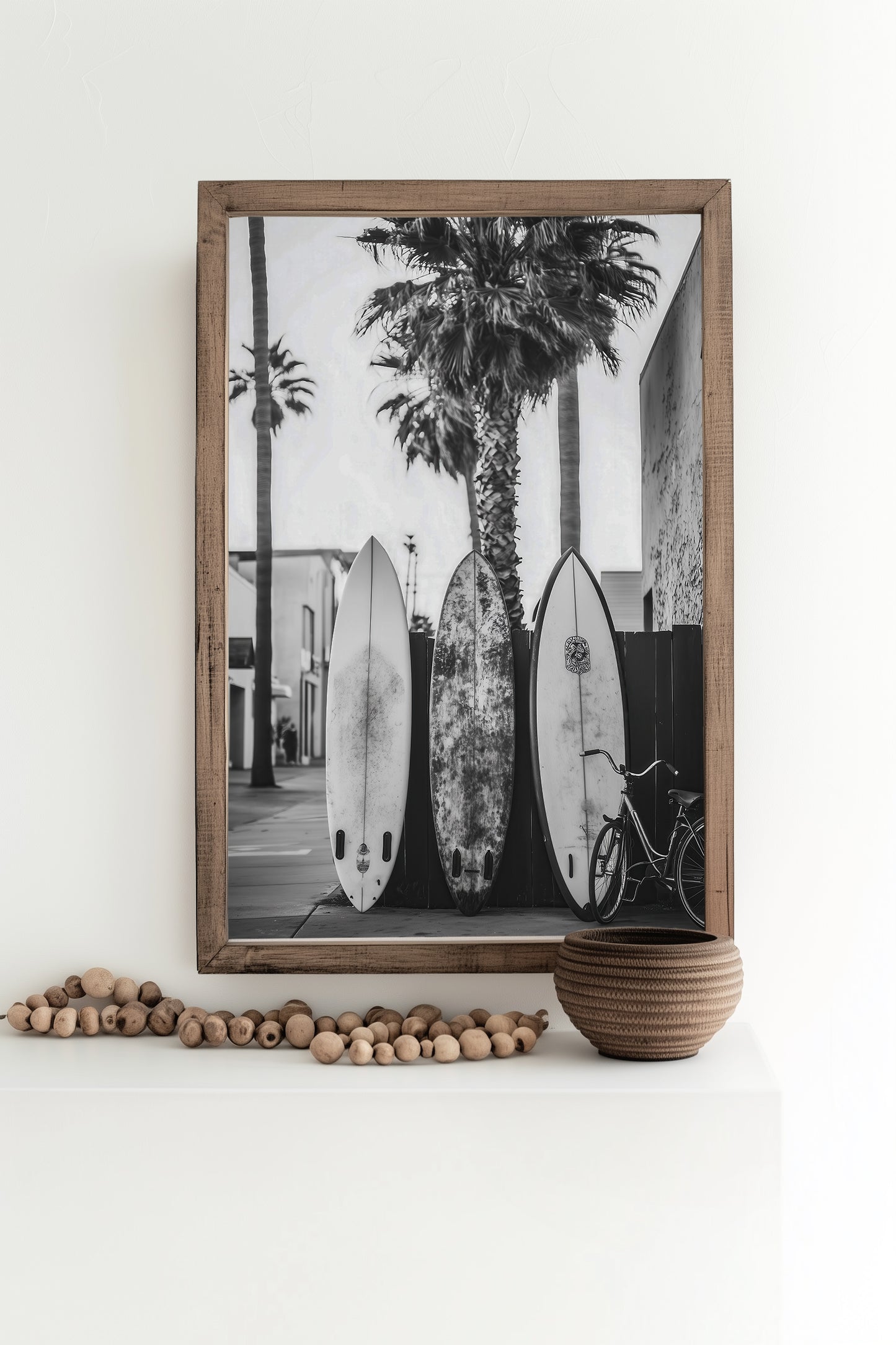 Black and white photograph of surfboards resting against palm trees on a tropical beach, perfect for vintage surf-inspired decor and coastal homes.