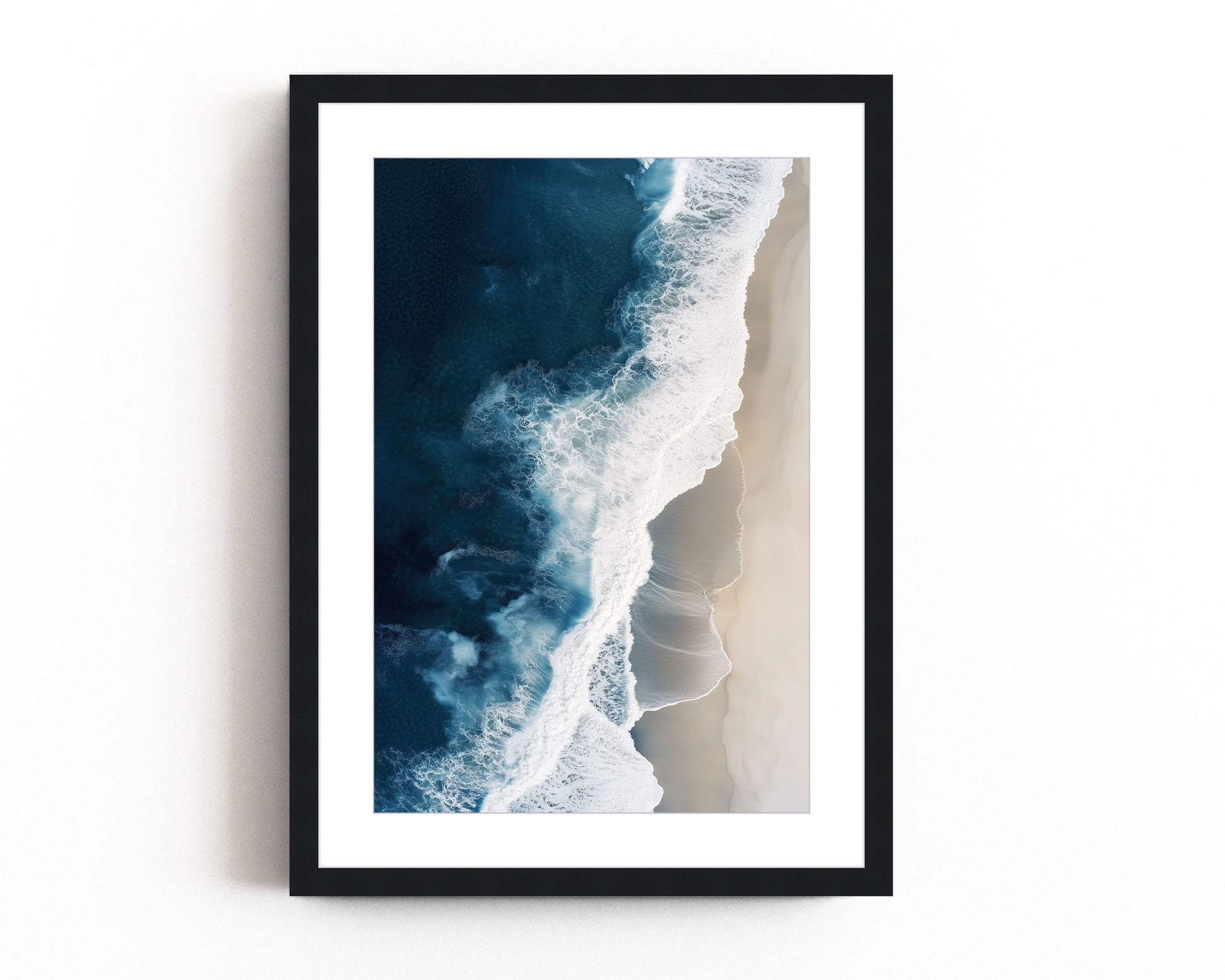 Aerial view of ocean waves crashing onto a sandy beach, showcasing deep blue waters and minimalist coastal scenery, perfect for modern beach home decor.