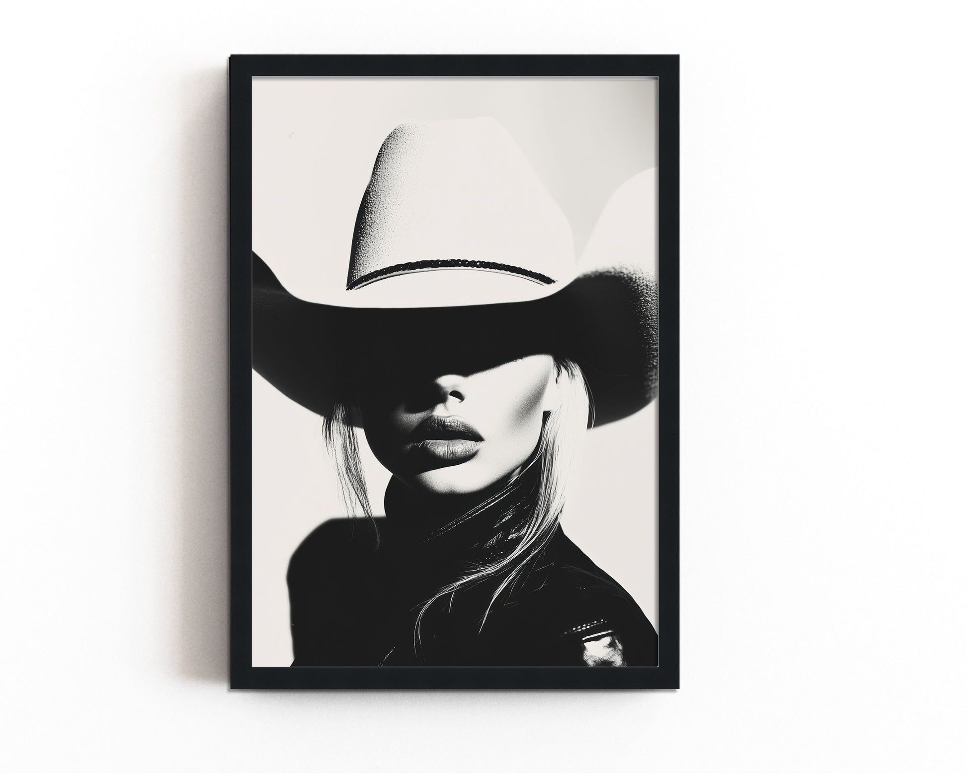 High-contrast black-and-white portrait of a model wearing a cowboy hat, blending minimalist western aesthetics with modern sophistication.