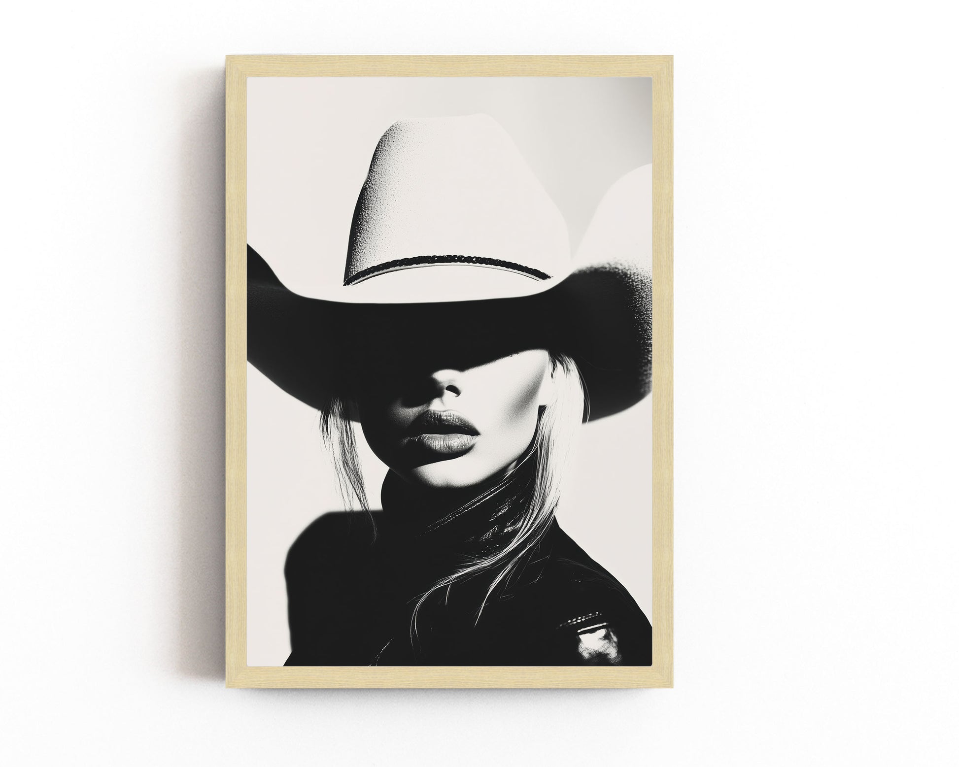 High-contrast black-and-white portrait of a model wearing a cowboy hat, blending minimalist western aesthetics with modern sophistication.