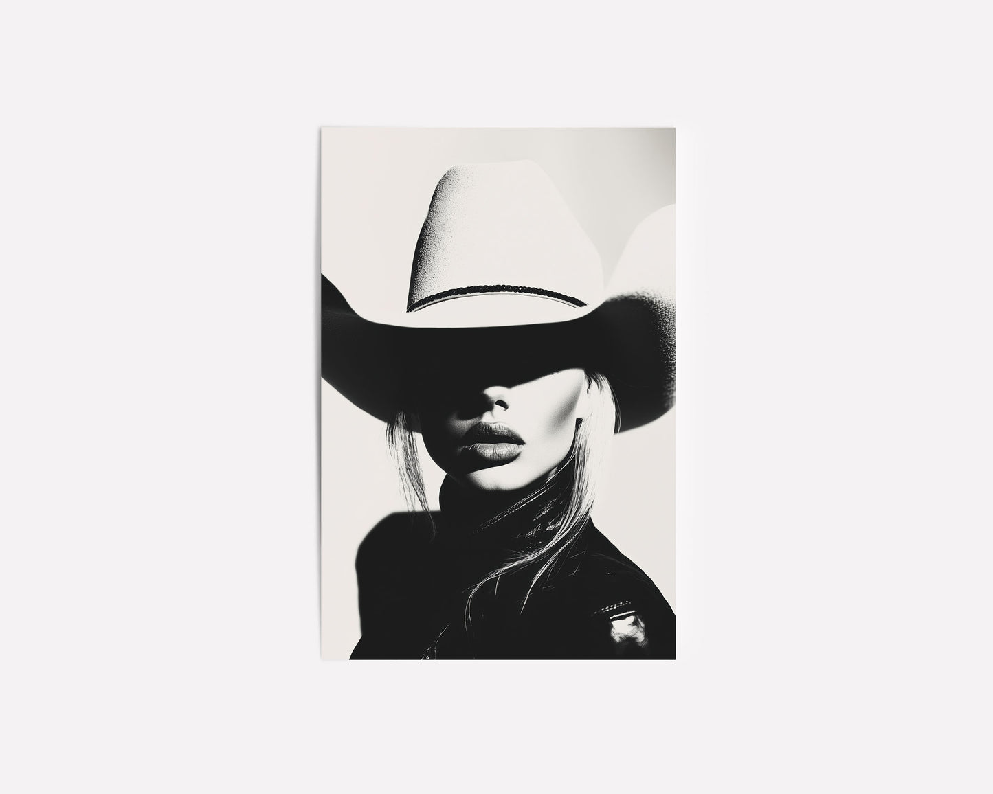 High-contrast black-and-white portrait of a model wearing a cowboy hat, blending minimalist western aesthetics with modern sophistication.