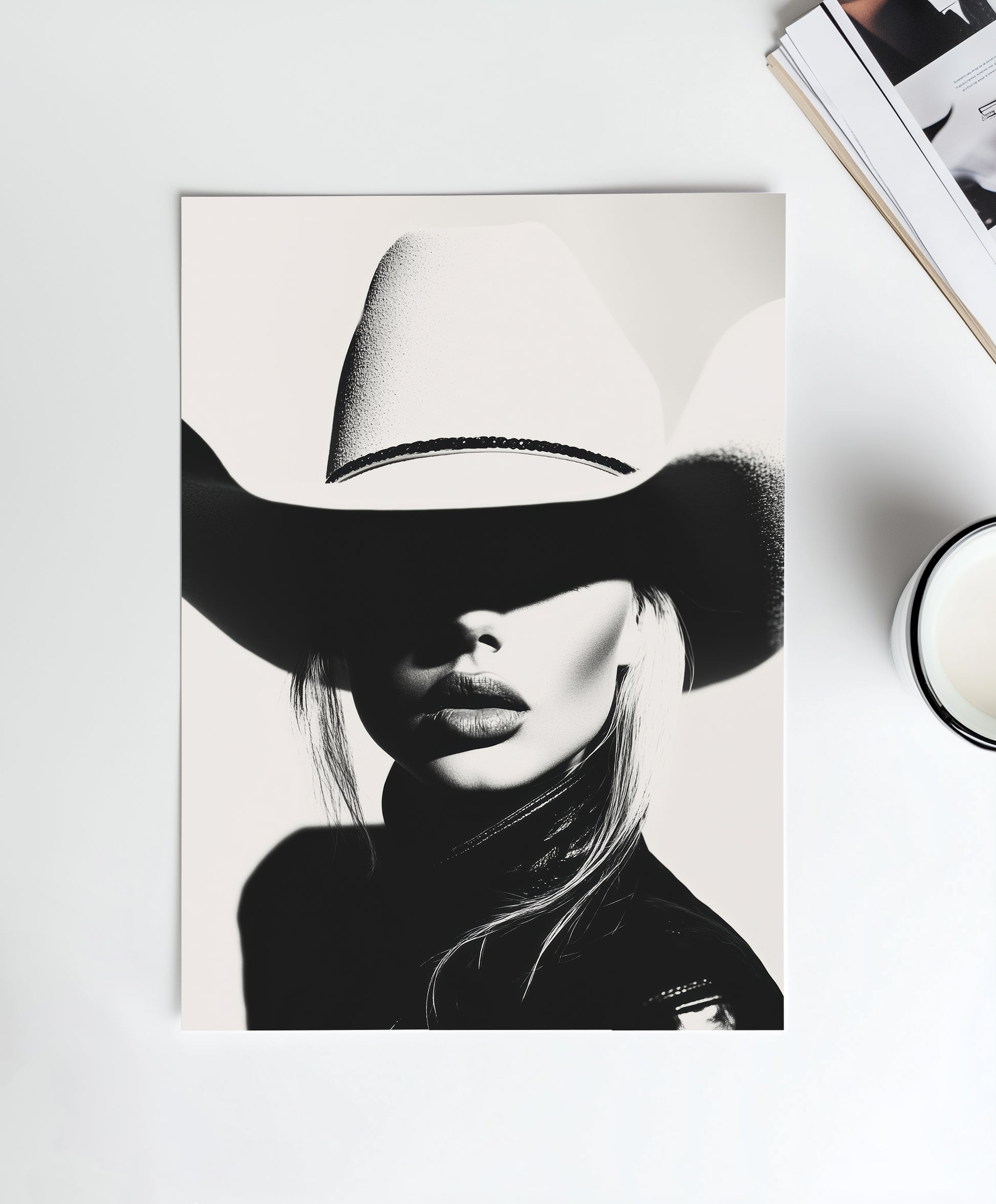 High-contrast black-and-white portrait of a model wearing a cowboy hat, blending minimalist western aesthetics with modern sophistication.