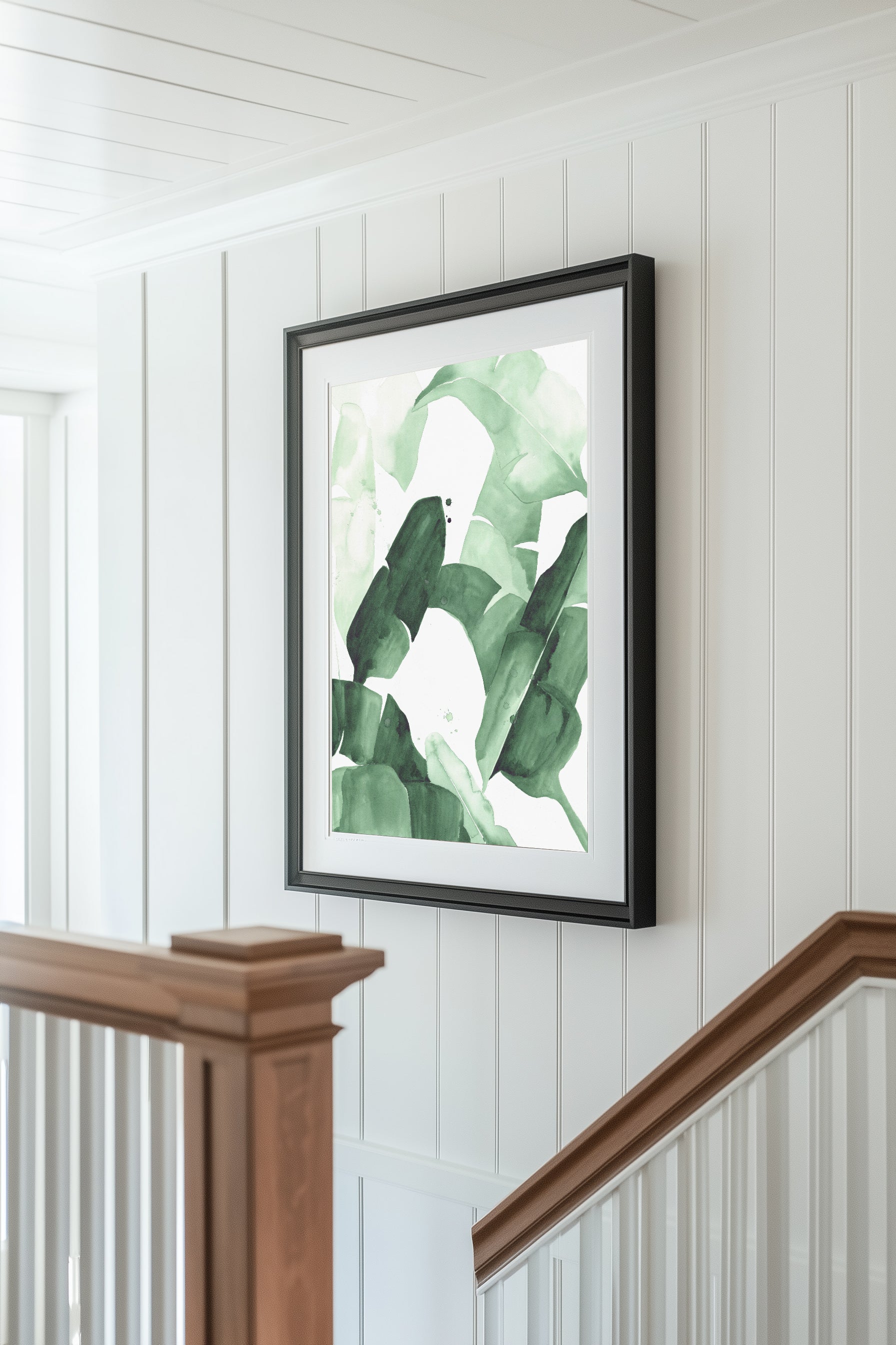 Abstract watercolor painting of tropical banana leaves in varying shades of green, featuring bold brushstrokes and layered textures, framed in blac