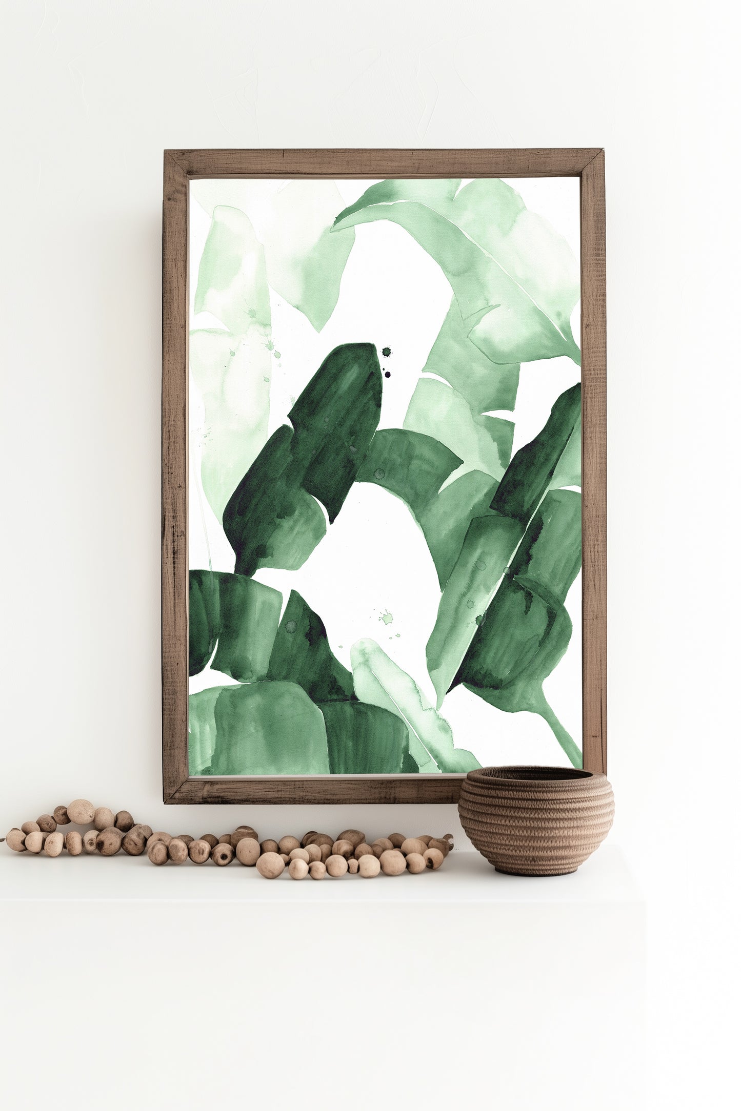 Abstract watercolor painting of tropical banana leaves in varying shades of green, featuring bold brushstrokes and layered textures, framed in blac