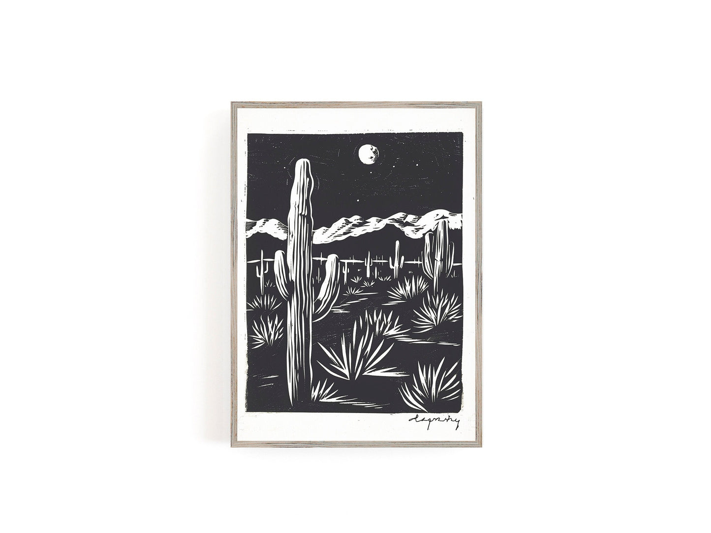 Black and white print featuring a cactus and desert landscape under a full moon, showcasing a minimalist Southwestern scene.