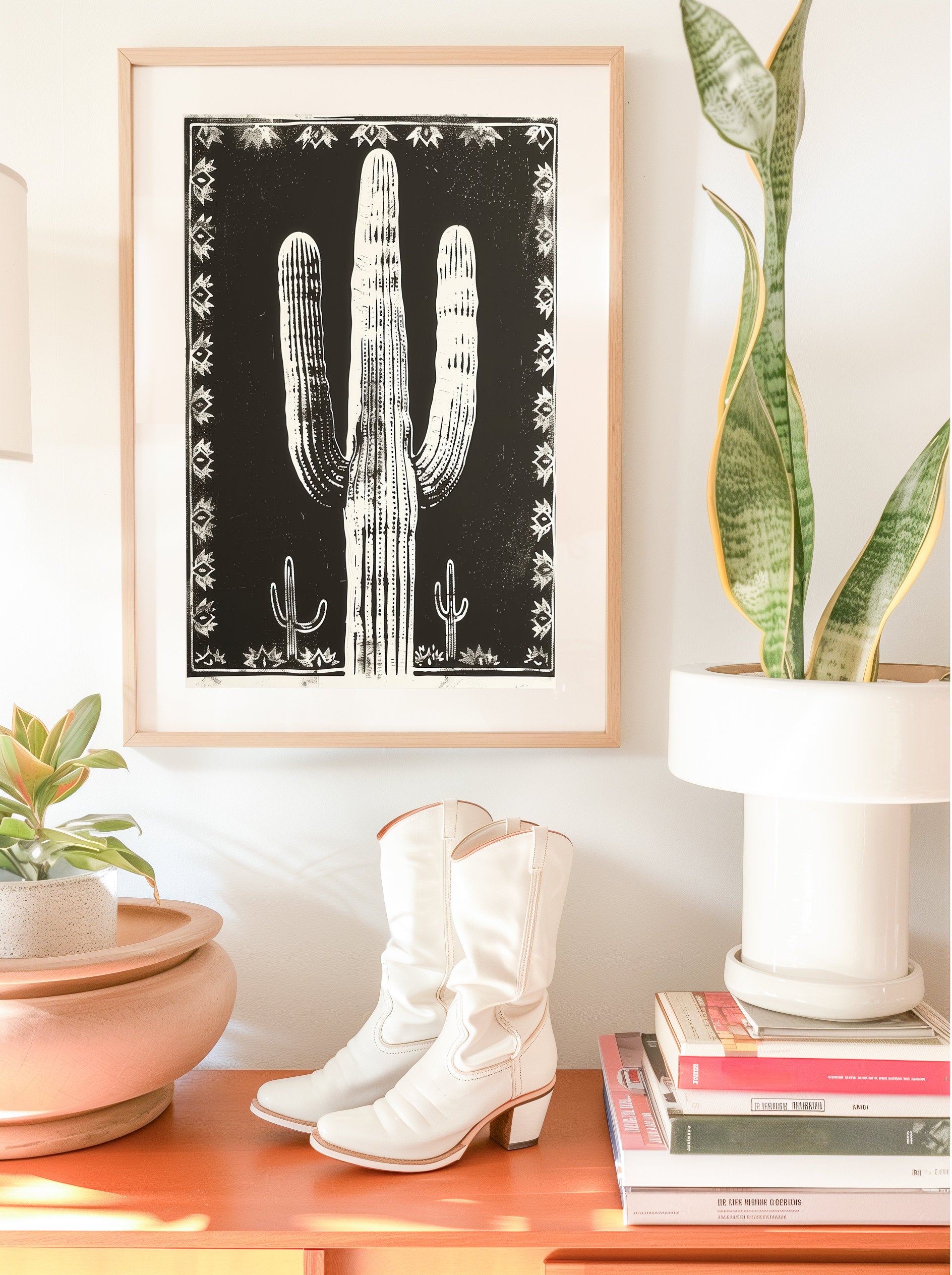 Southwestern-inspired cactus wall art featuring a bold saguaro cactus in neutral tones, framed with intricate designs on a black background.