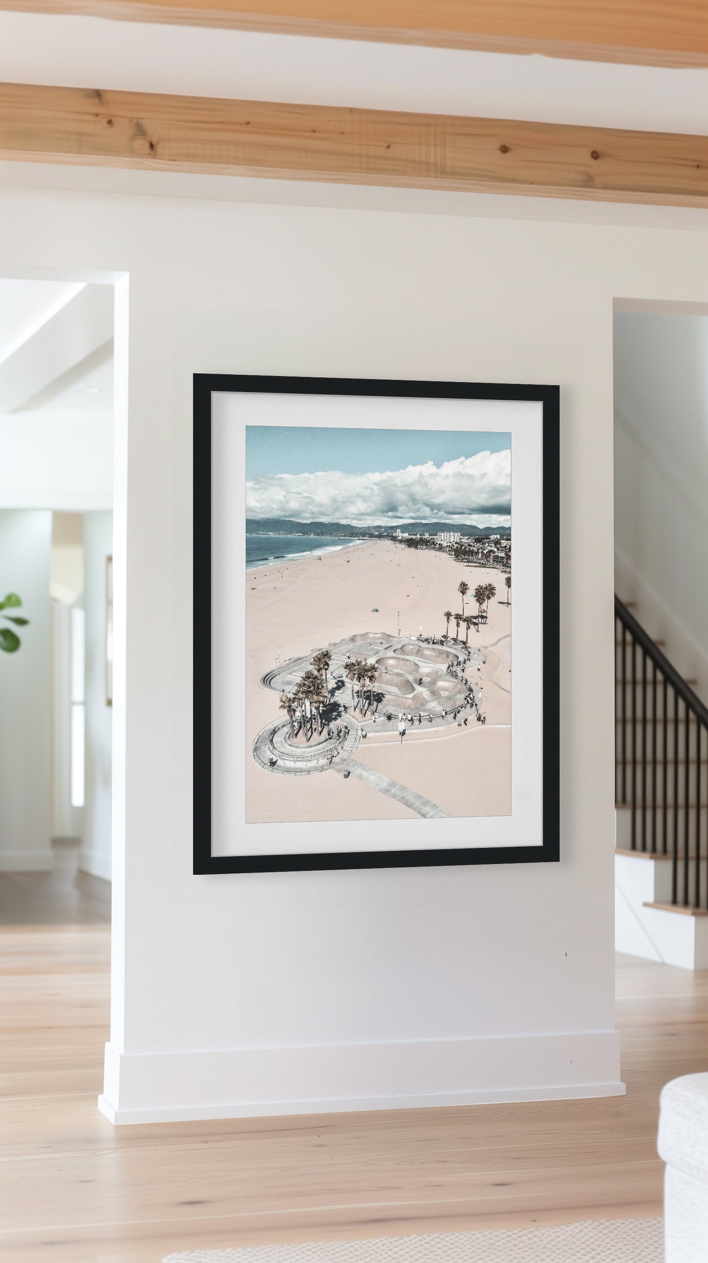 Aerial beach photography of Venice Beach skatepark, featuring golden sands, palm trees, and the Pacific Ocean, blending urban and coastal vibes.
