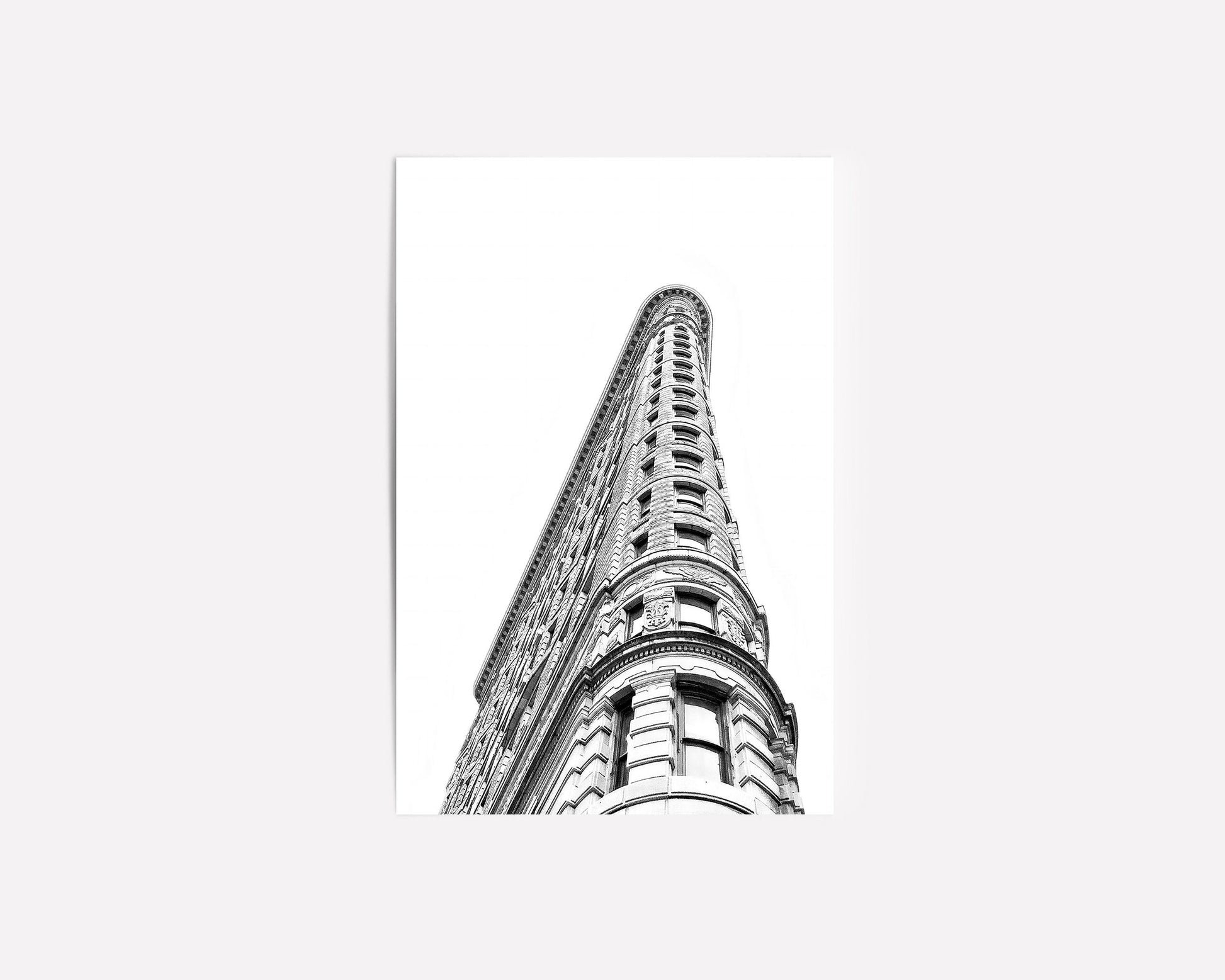 Black and white photography of the Flatiron Building in New York City, showcasing its iconic architectural elegance and bold structure.