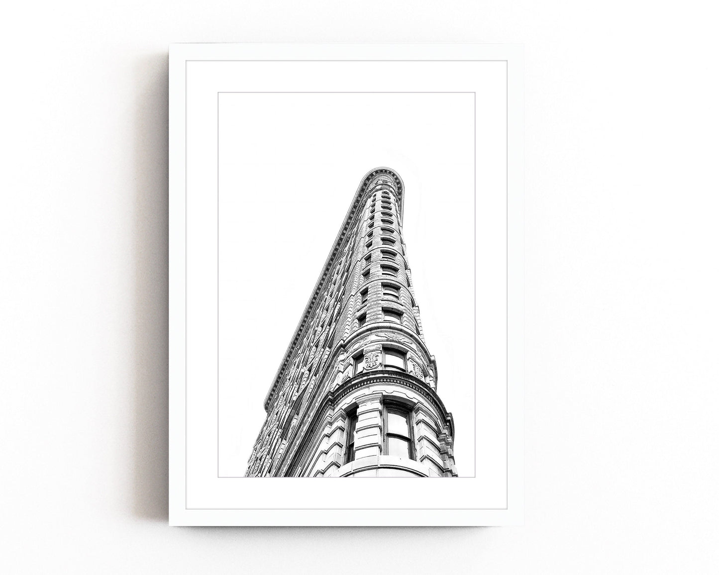 Black and white photography of the Flatiron Building in New York City, showcasing its iconic architectural elegance and bold structure.