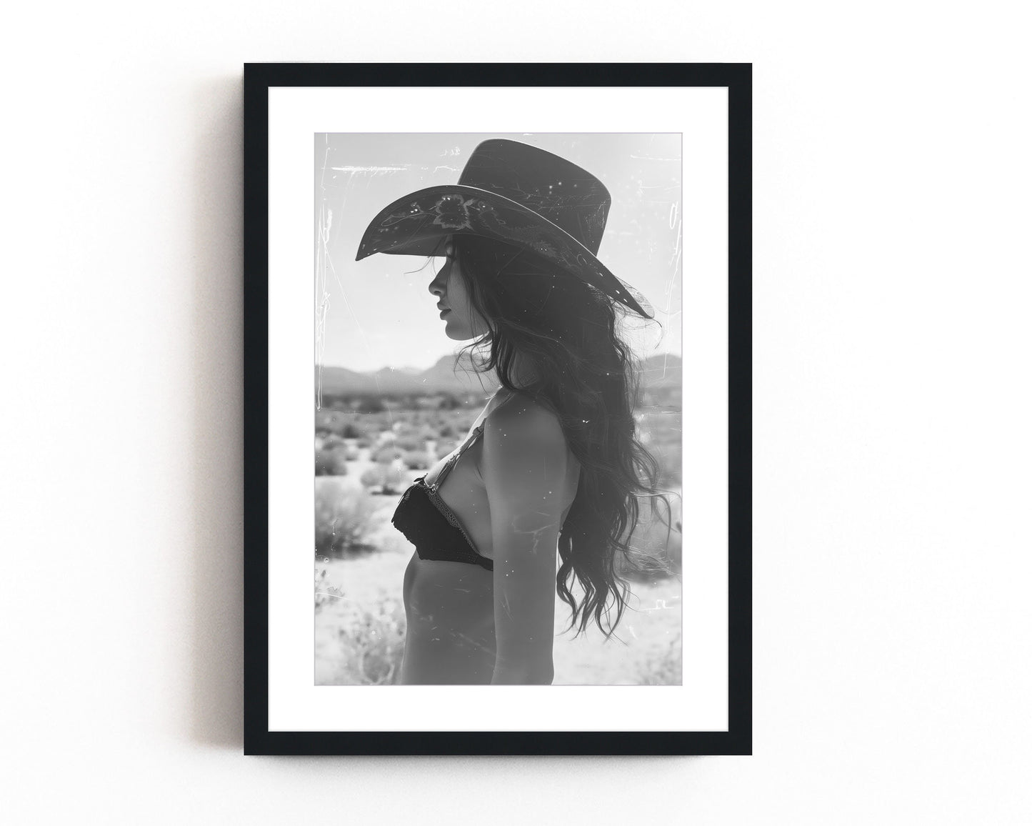 Black and white western cowgirl portrait with vintage film marks and scratches, evoking a southwestern desert vibe with retro photography style.