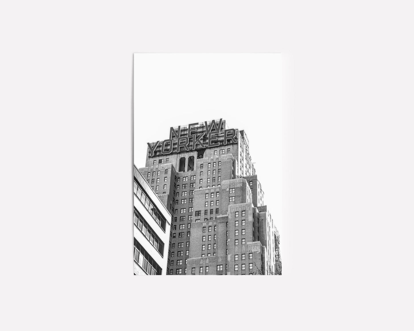 Black and white art print of the iconic New Yorker building in Manhattan, showcasing urban skyscraper architecture with a vintage cityscape feel.