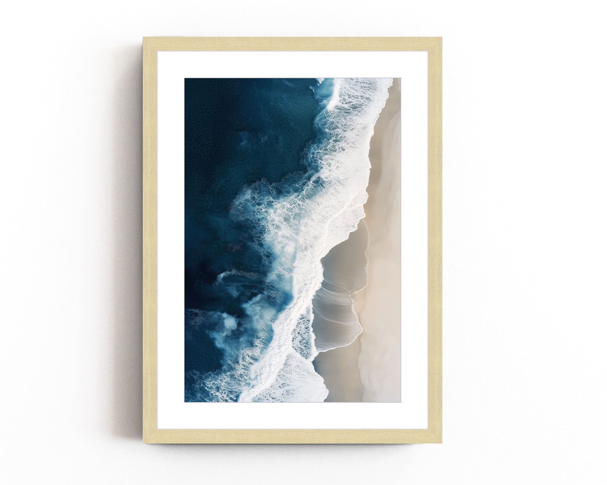 Aerial view of ocean waves crashing onto a sandy beach, showcasing deep blue waters and minimalist coastal scenery, perfect for modern beach home decor.