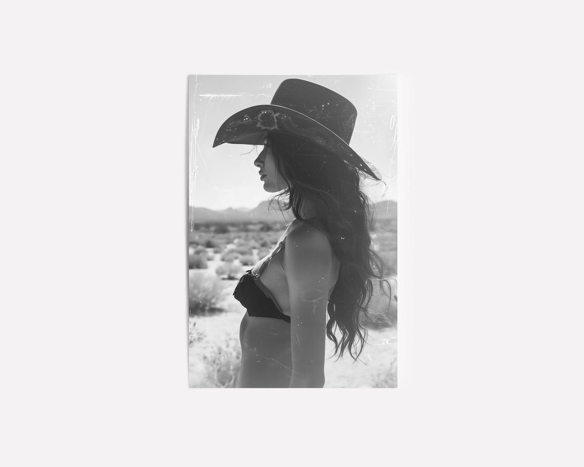 Black and white western cowgirl portrait with vintage film marks and scratches, evoking a southwestern desert vibe with retro photography style.